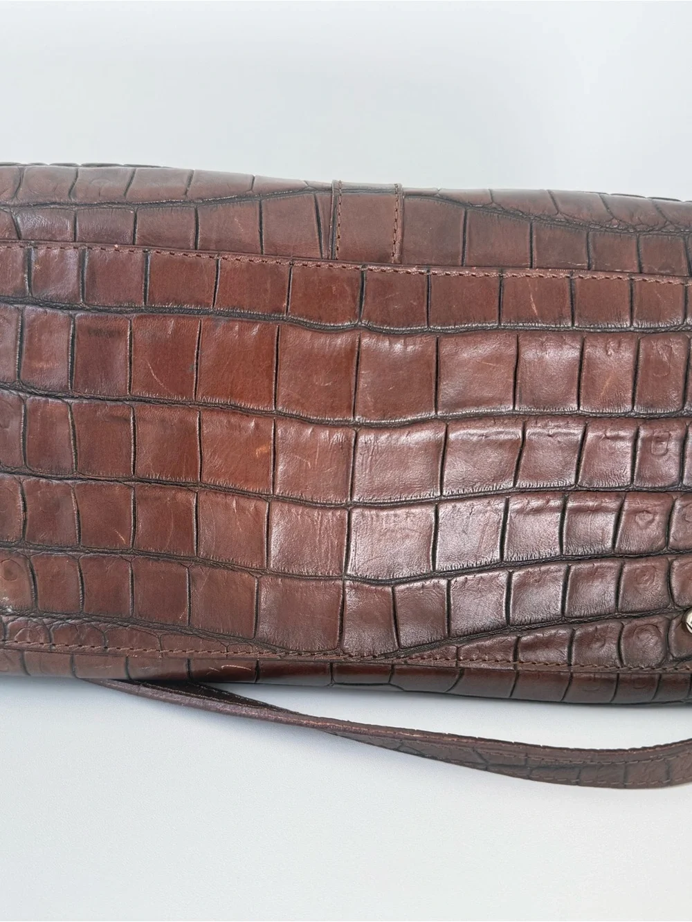 Dooney & Bourke, crafted from rich brown crocodile-embossed leather